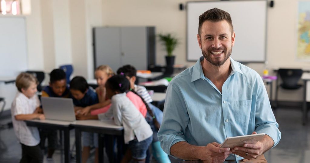 Male teacher with kids in background