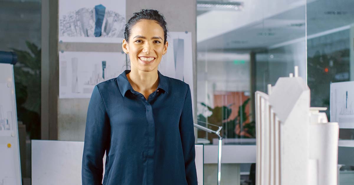 Woman in office with architecture designs and scale buildings