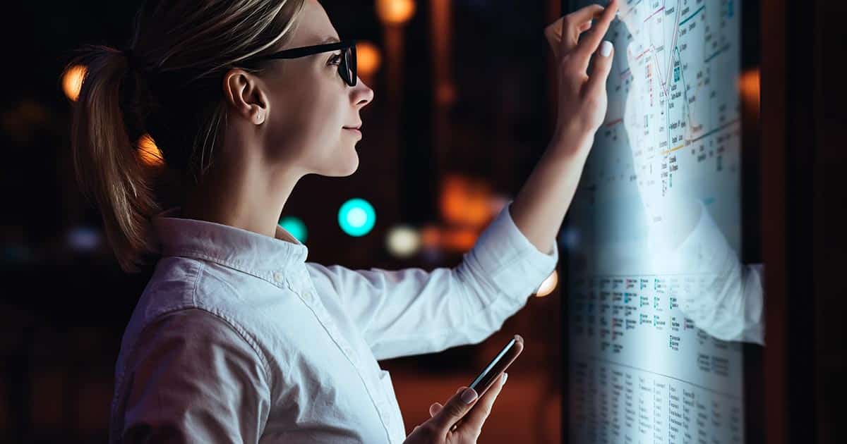 Woman examining transport schedules and map