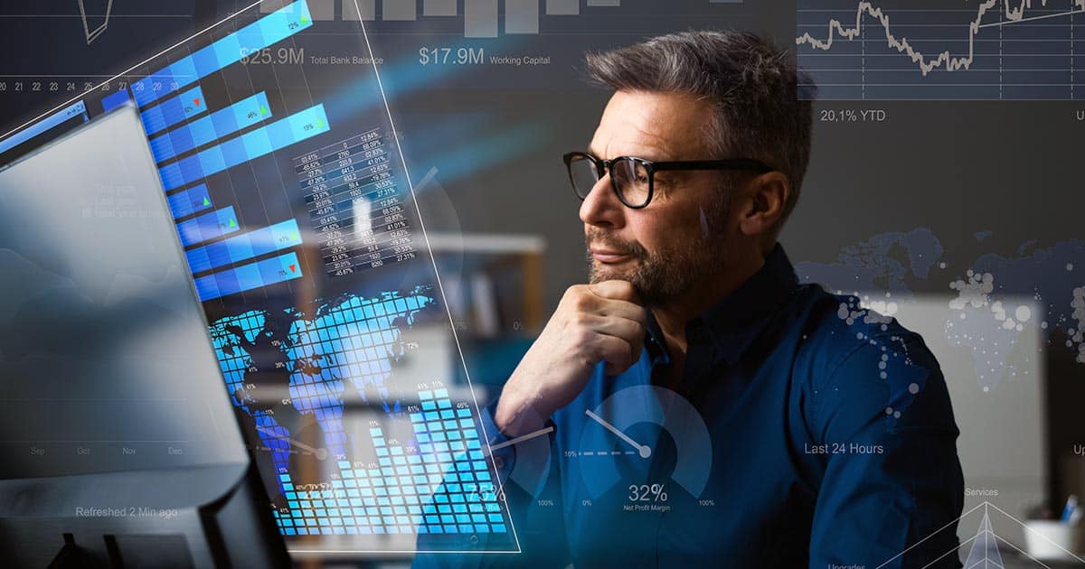 Professional man with hand to chin contemplating charts