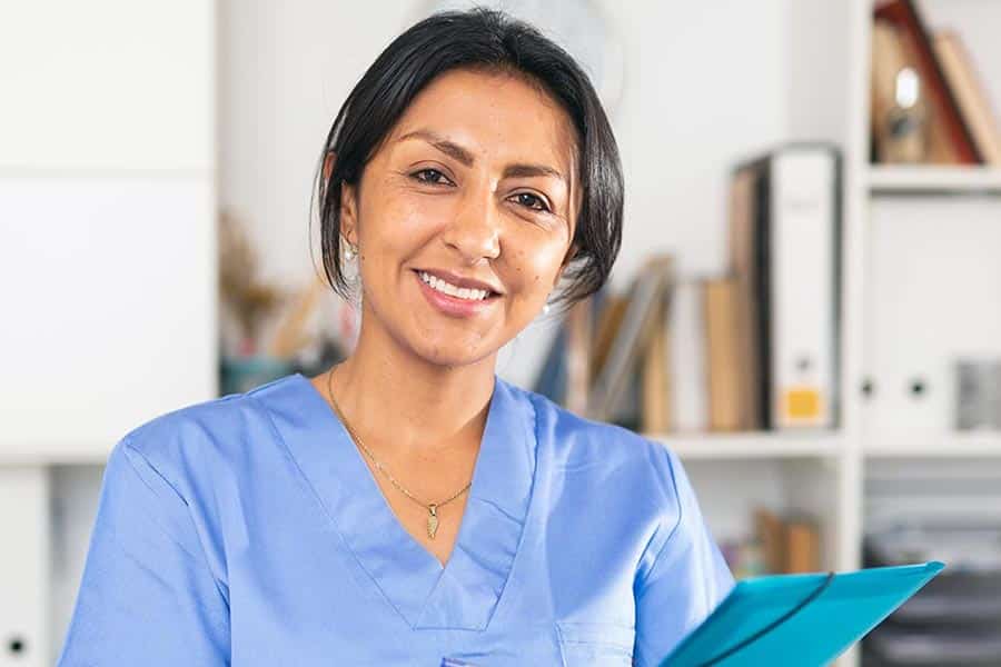 Woman in blue scrubs with document
