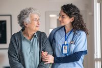 Nurse assists elderly woman walk