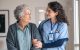 Nurse assists elderly woman walk