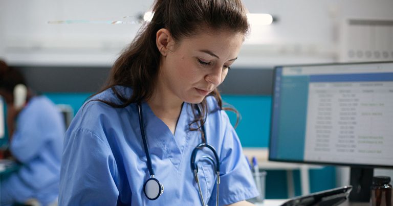Nurse checking notes at desk