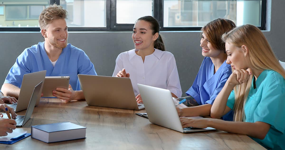 Nurse educator instructing a small group of trainees