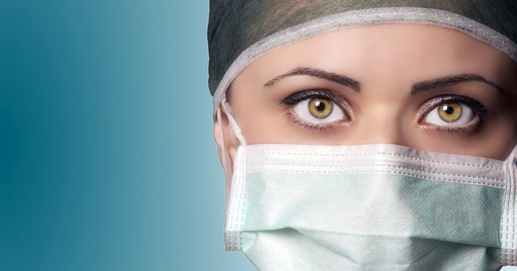 Close up of health professional with hair net and surgical mask