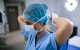 Nurse tying facemask in operating room