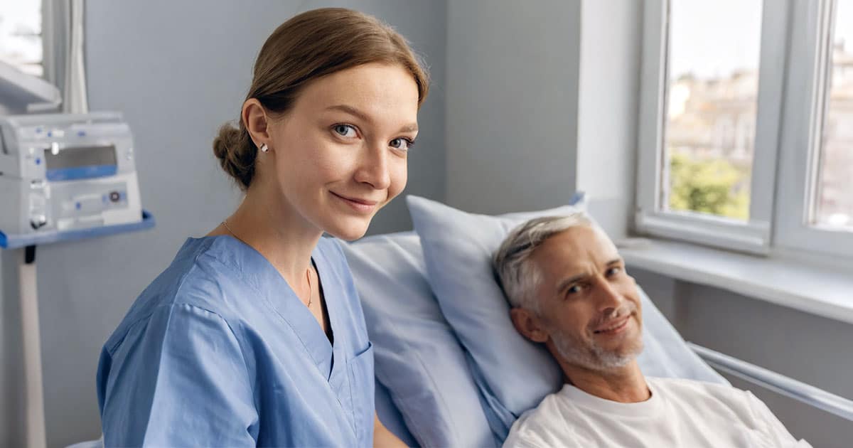 Nurse with middle-aged male patient in hospital bed