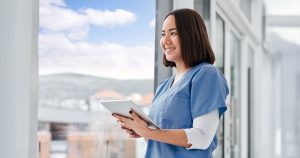 Nurse with tablet looking out window