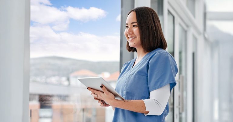 Nurse with tablet looking out window