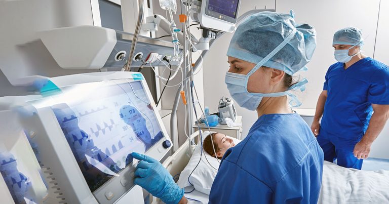Nurses checking patient vitals in intensive care unit