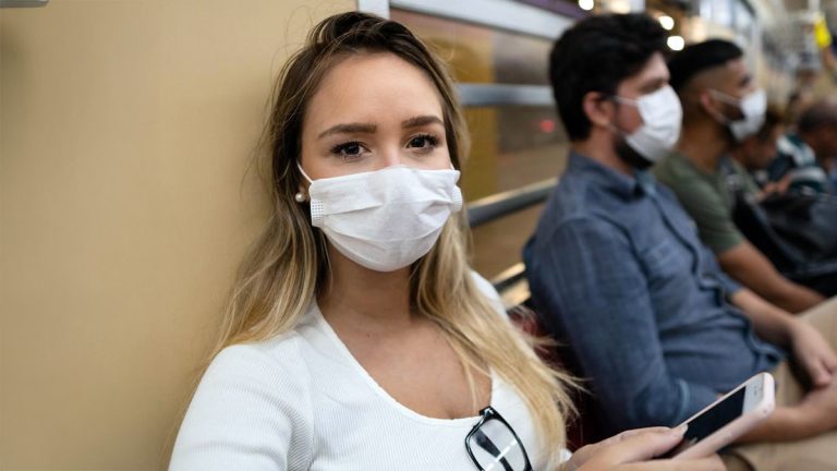 Row of people wearing masks on train