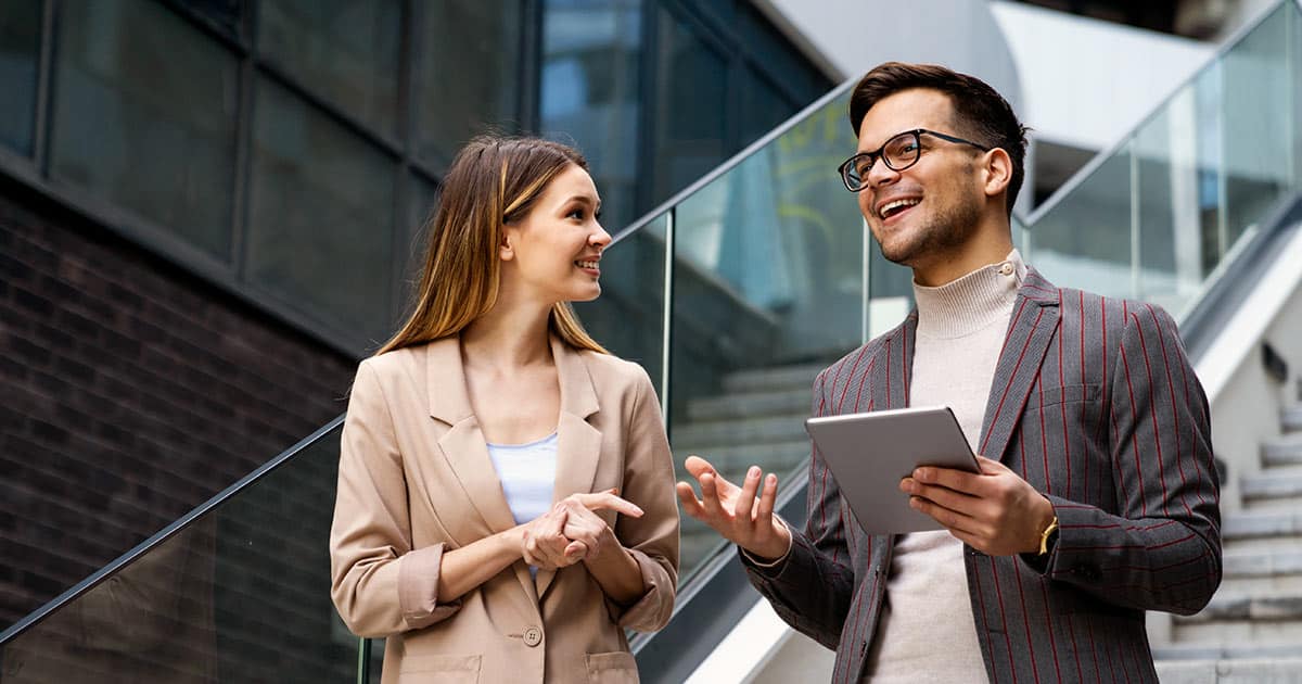 Professional colleagues talking on steps of modern building