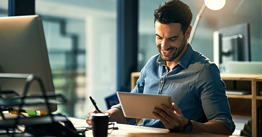 Professional man working in office with computer tablet and pen