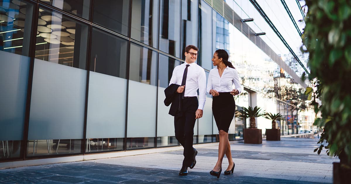 Professionals walking outside contemporary city building