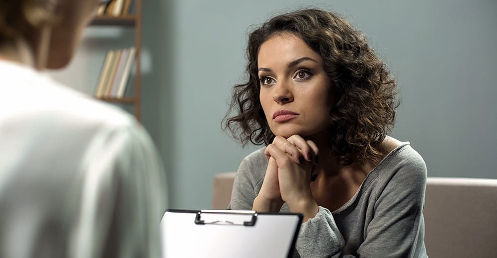 Woman intently paying attention to woman with clipboard