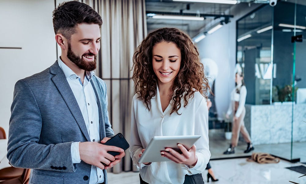 Professional man and woman reviewing notes while standing