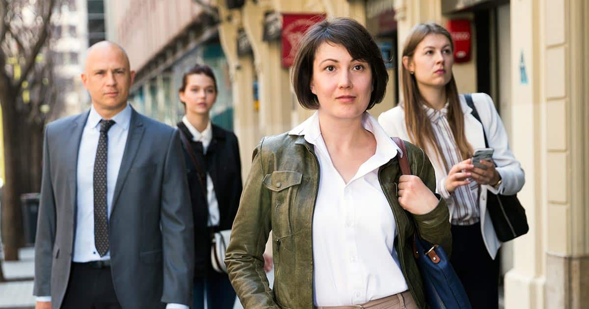 Well-dressed people in the community walking along footpath