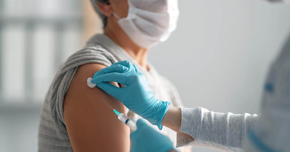 Woman receiving injection into shoulder