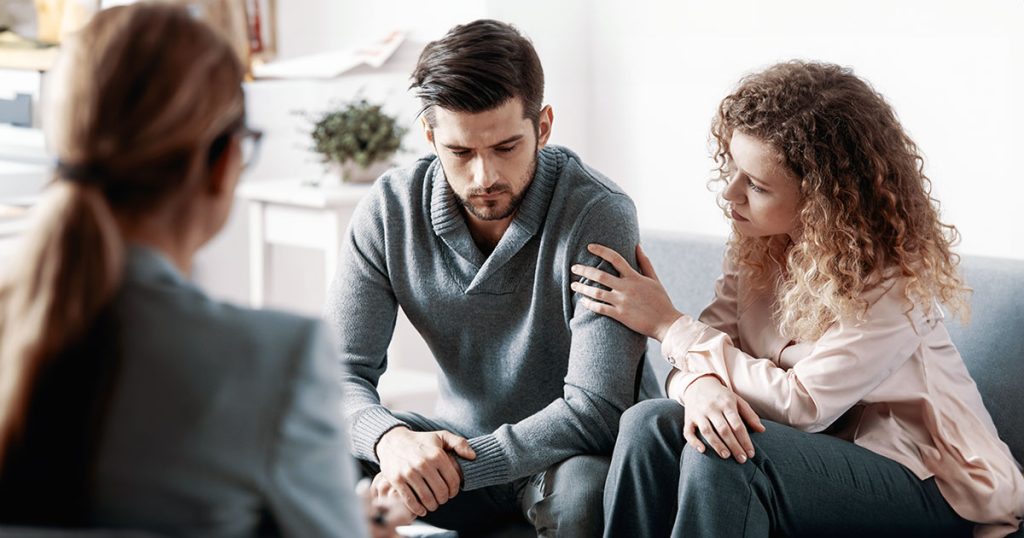 Relationship counselling with woman touching man's arm
