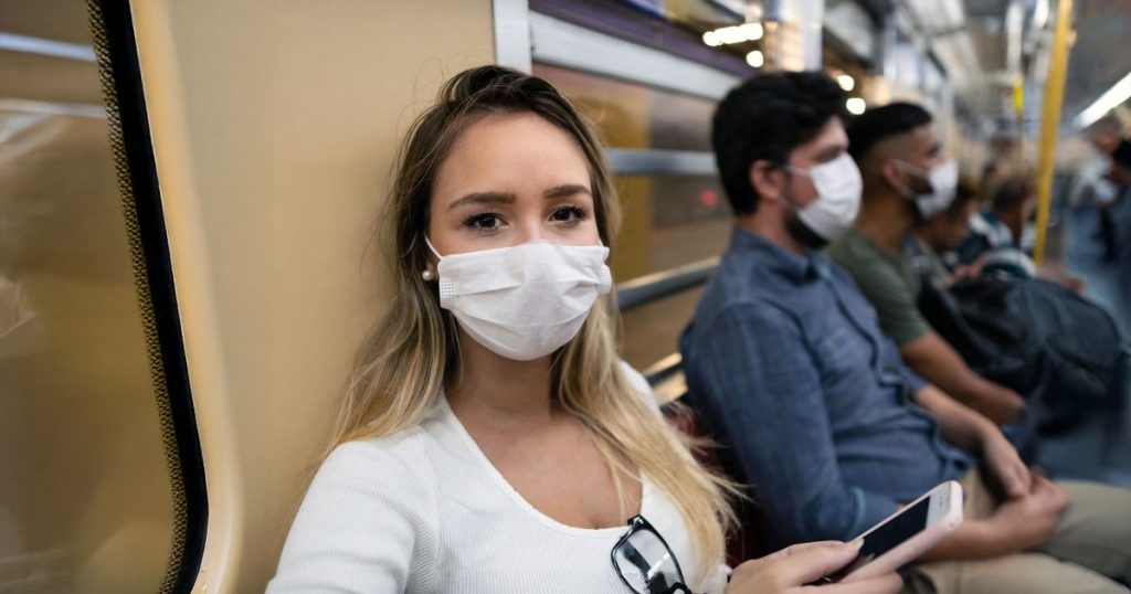 Row of people wearing masks on train