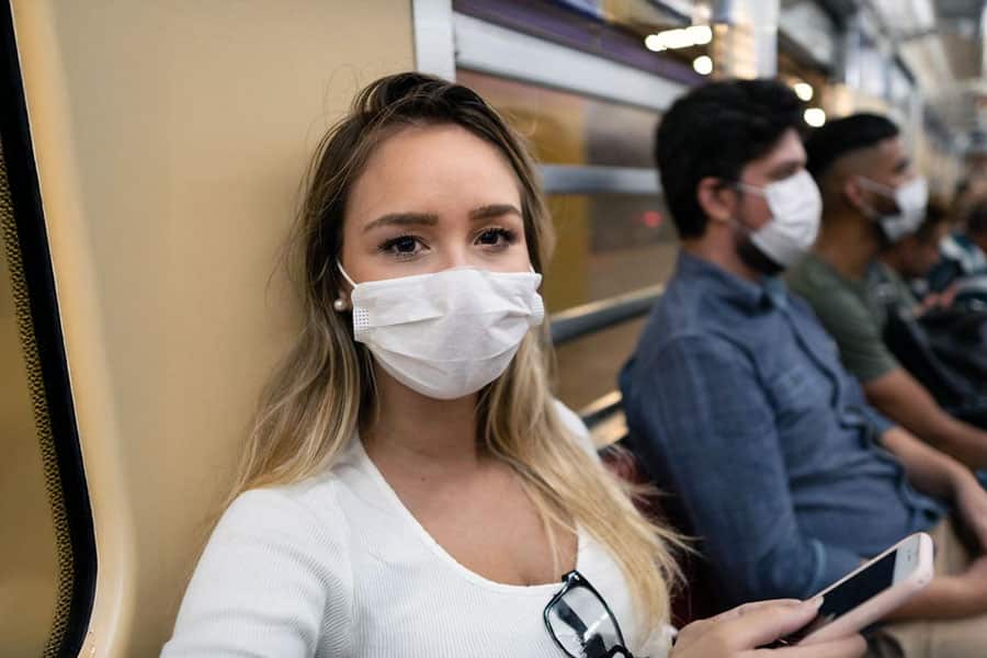 Row of people wearing masks on train