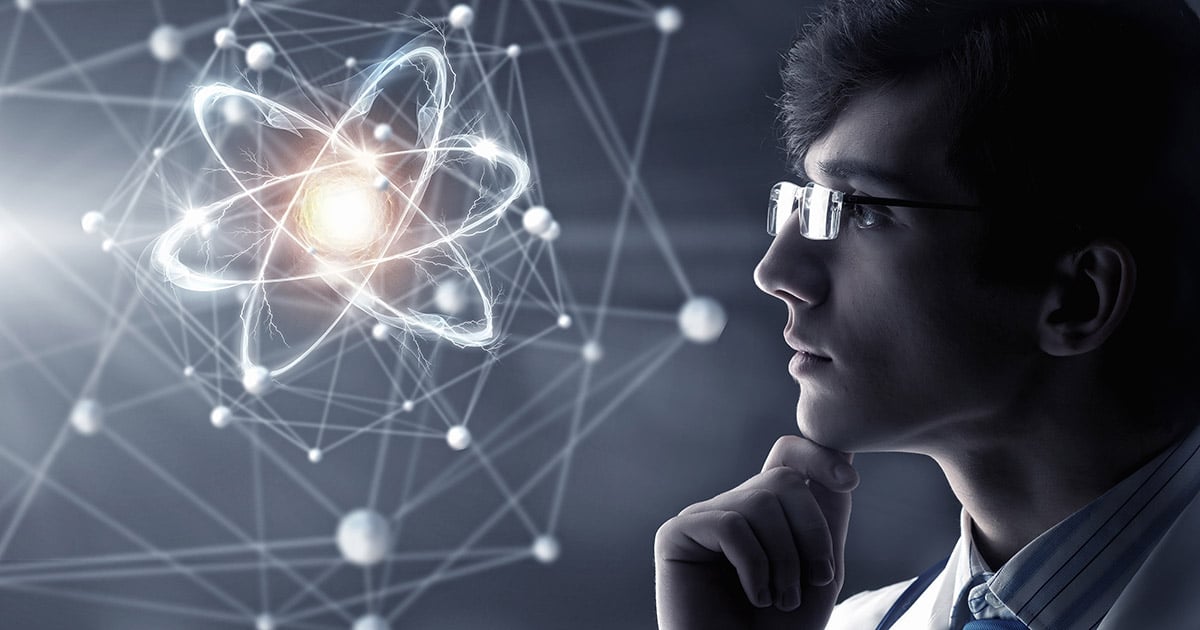 Man in a lab coat contemplating the structure of an atom