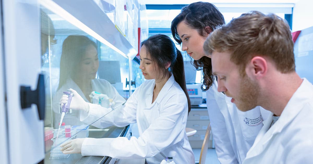 Science students using pipette in the lab