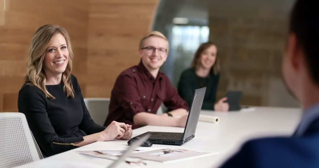 Staff smiling at man in meeting