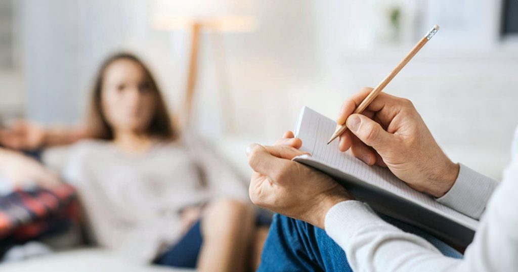 Therapist with patient taking notes