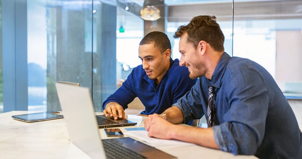 Two colleagues meeting using laptops