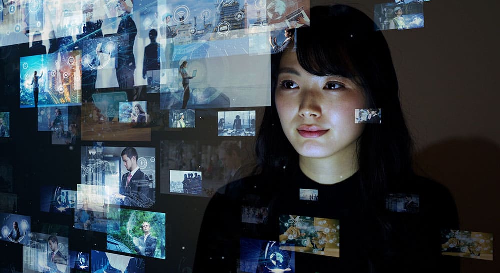Young woman looking at diverse images on large screen