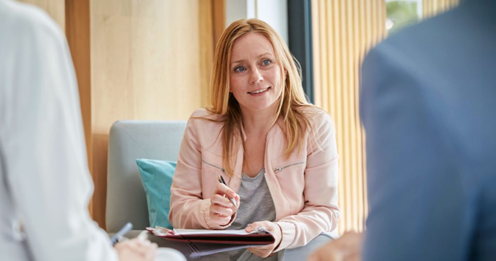 Woman taking notes during professional discussion