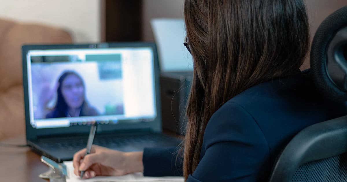 Woman taking notes during video call