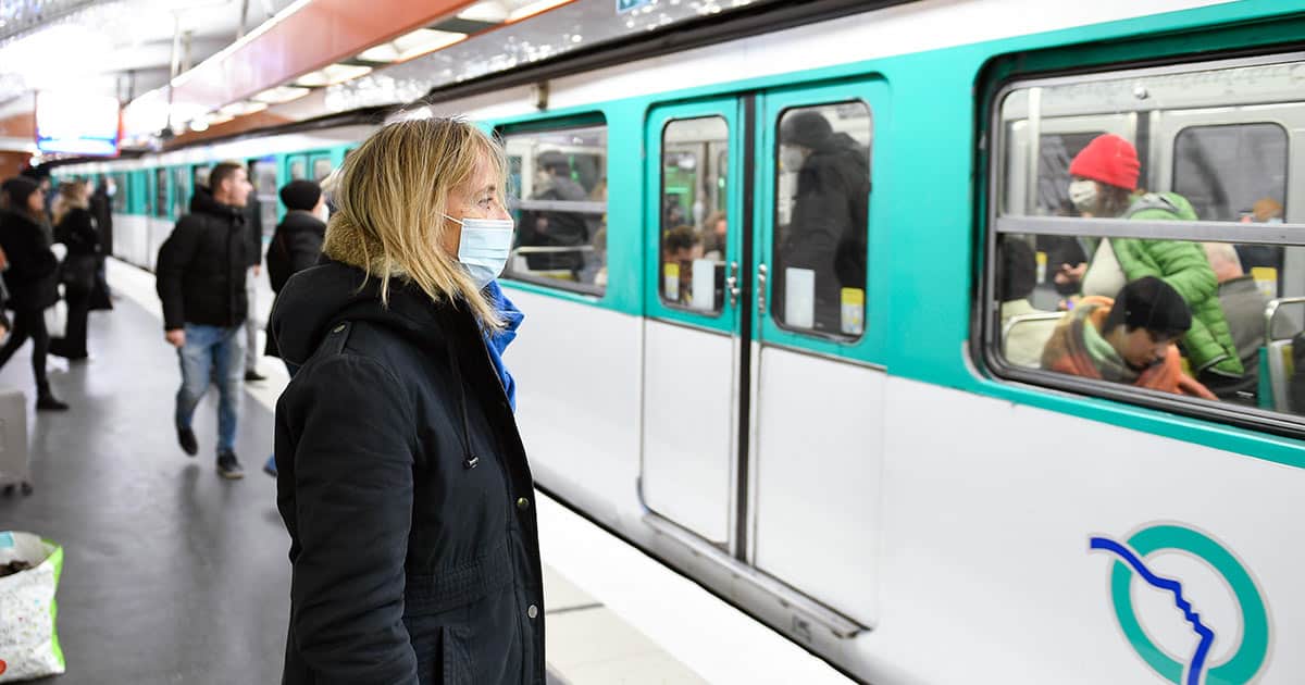 Woman wearing mask outside subway train