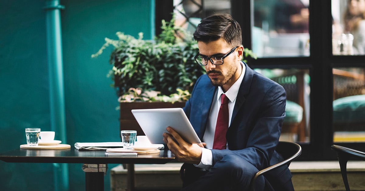 Professional man in café looking at computer tablet 