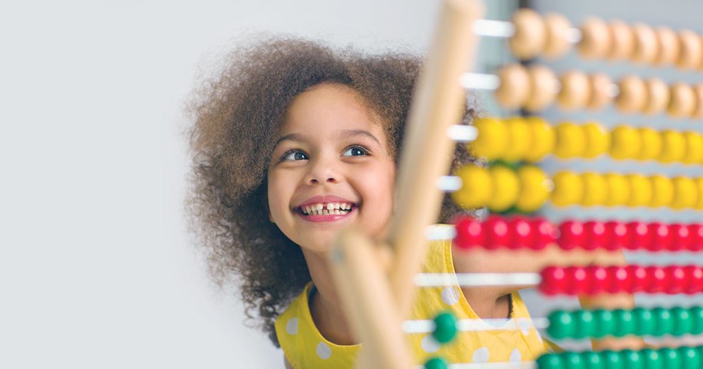 Young girl smiling at abacus