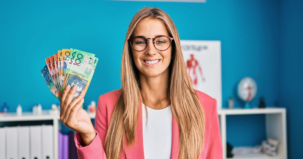Young woman holding Australian currency in medical office