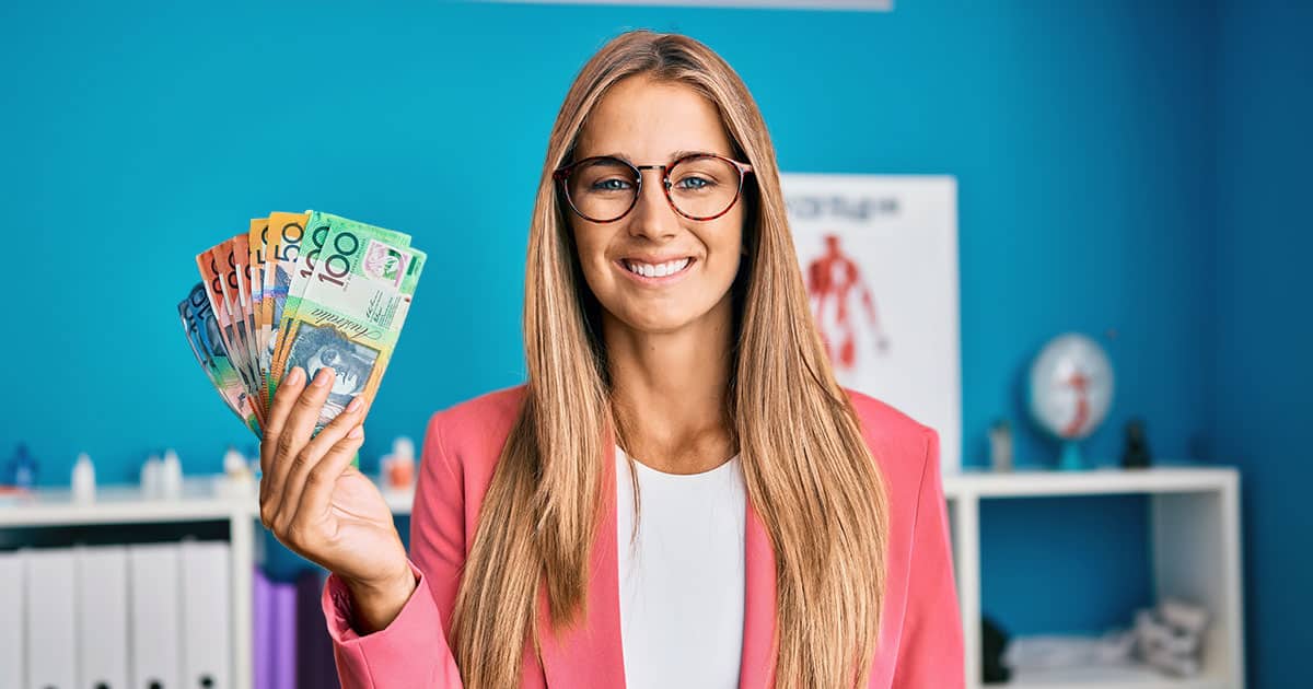 Young woman holding Australian currency in medical office