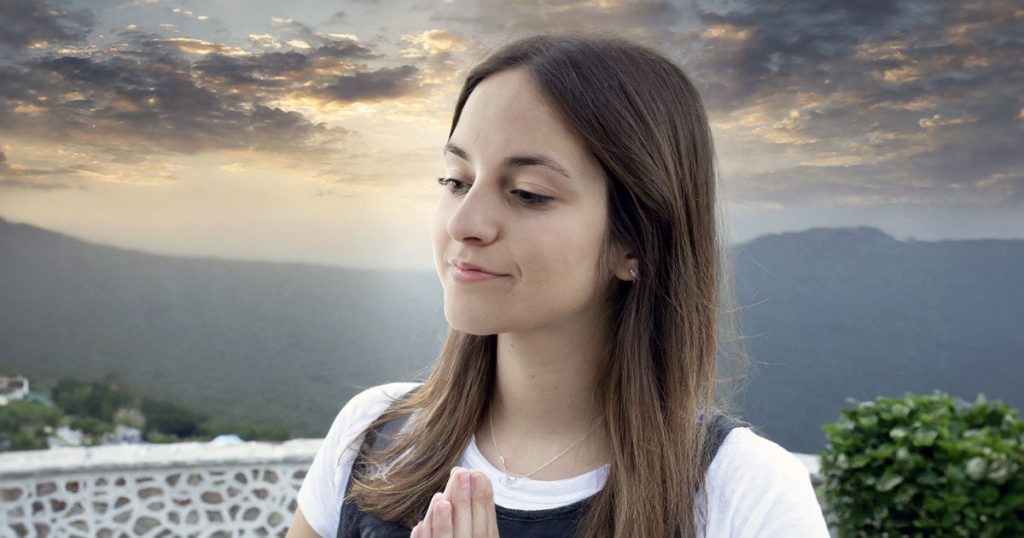 Young woman praying outside