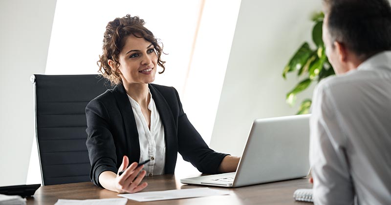 Female business executive in conversation behind her desk