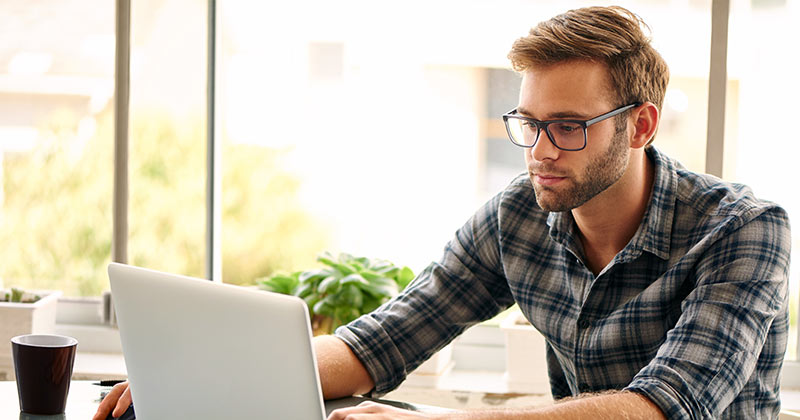 Young man studying using laptop