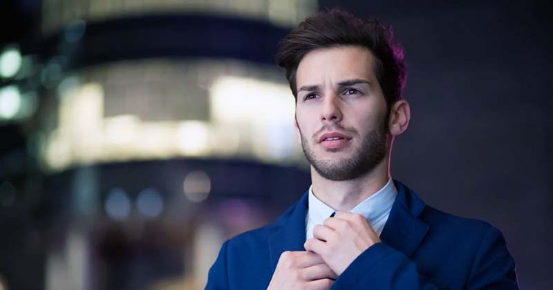 Business man adjusting tie