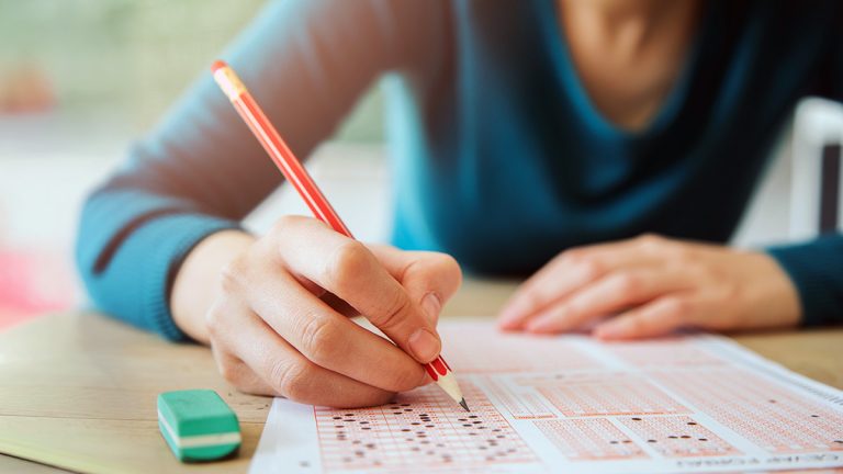 Female student using pencil for standardized test