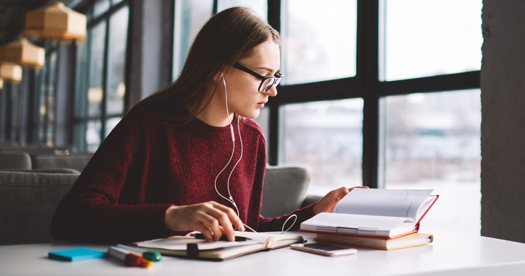 Female university student in library reading