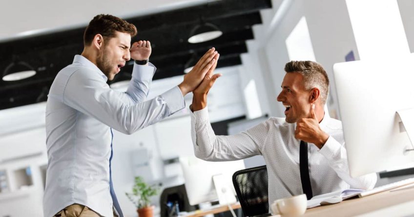 High five between two male professionals in office