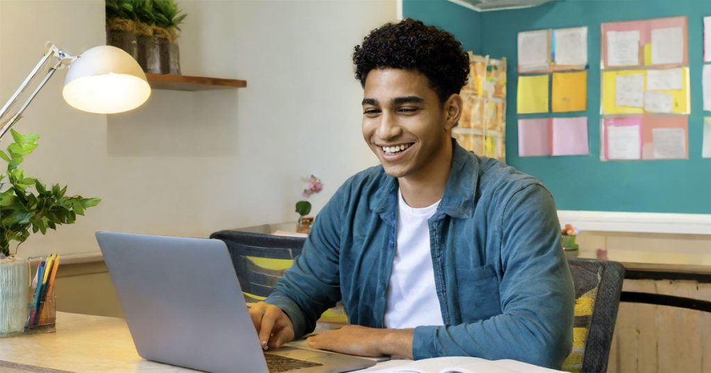 Male college student using laptop