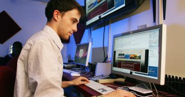 Man working online using multiple screens