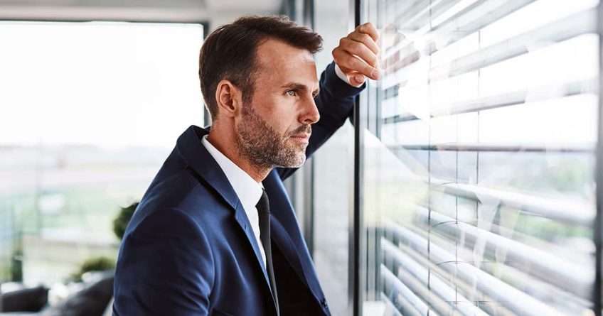 Thoughtful business man looking out of office window