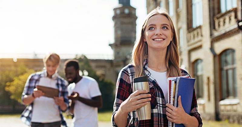 Young woman smiling as she walks on campus